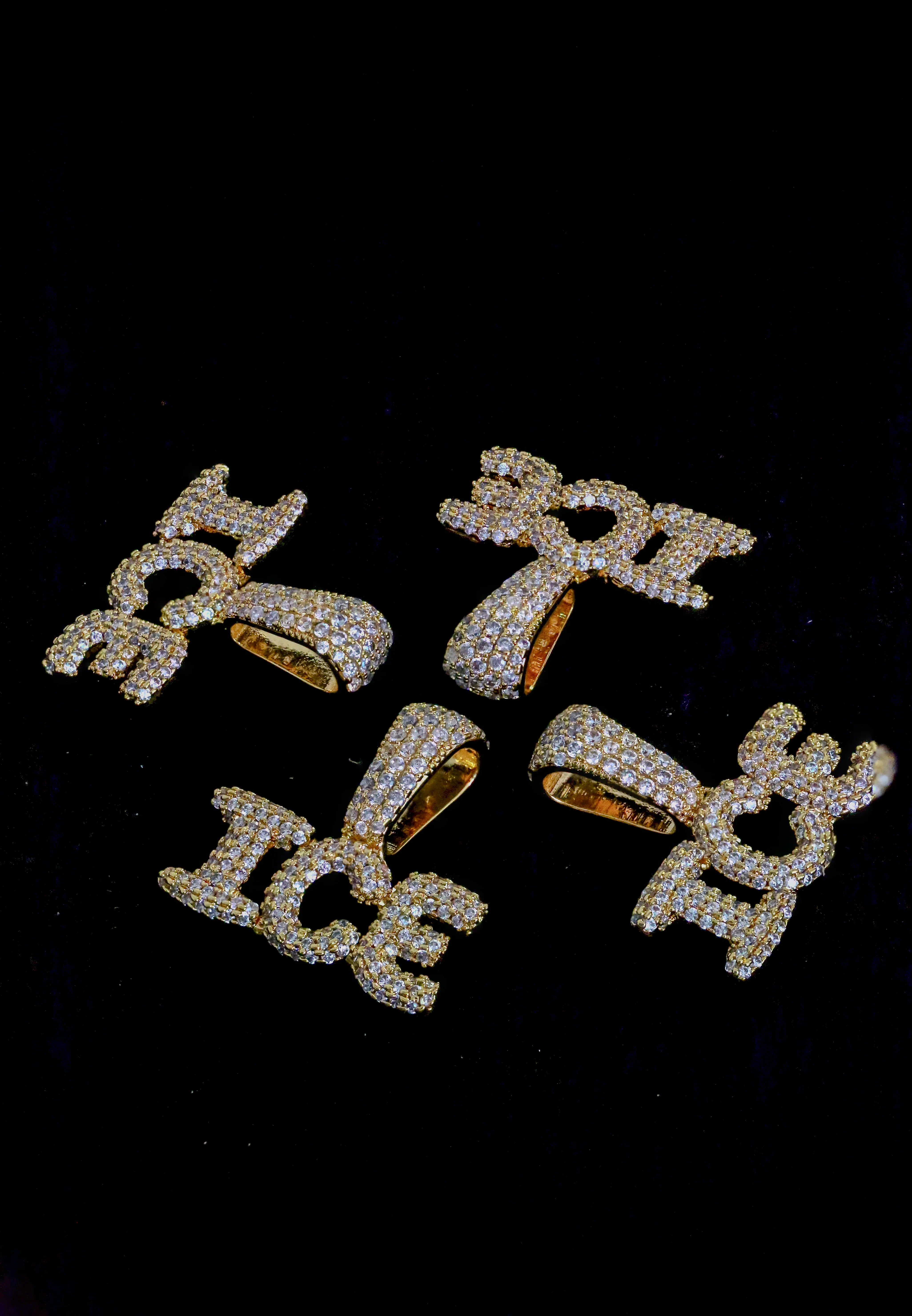 Gold and diamond-encrusted pendants on a black background