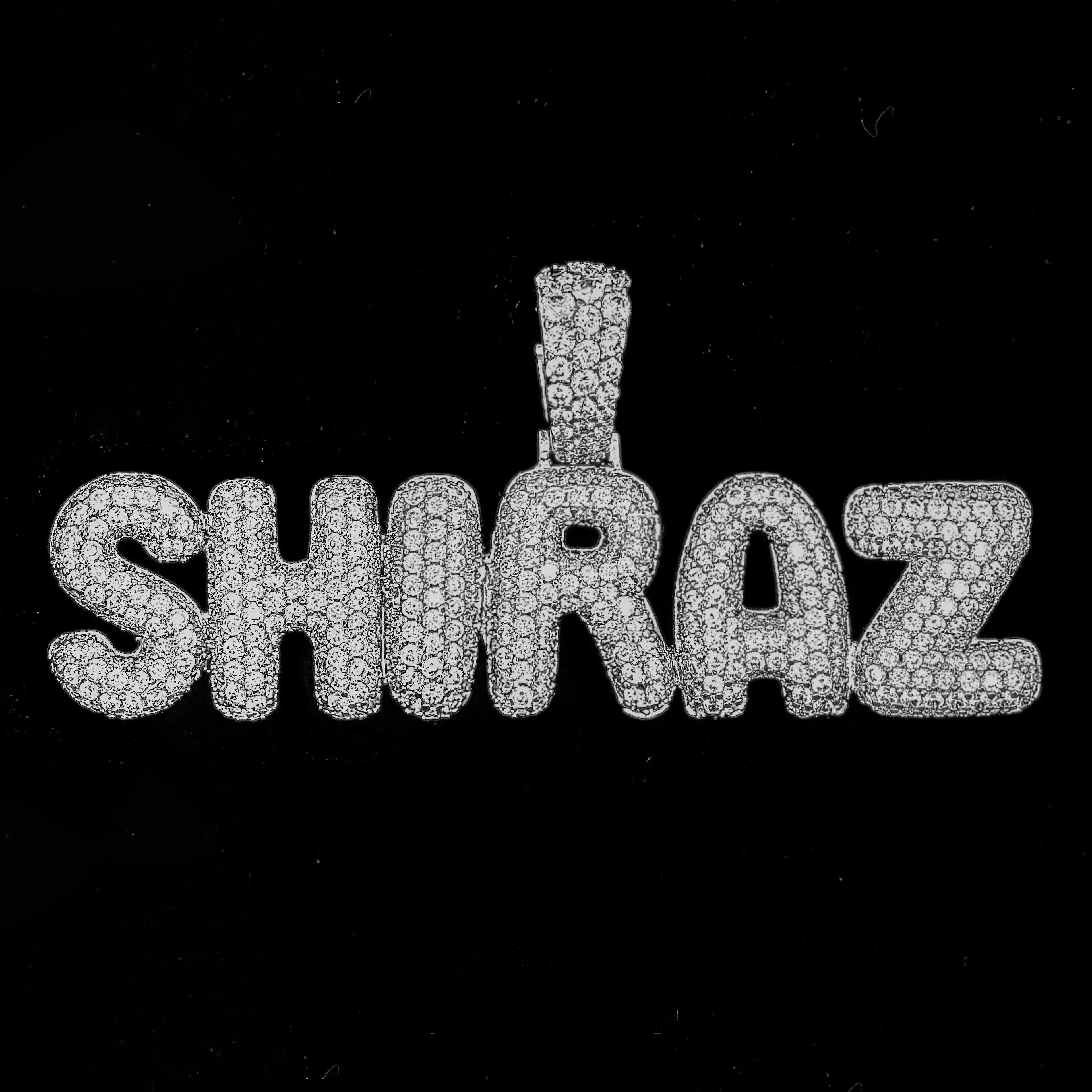 Diamond-encrusted pendant with 'SHIRAZ' on a black background