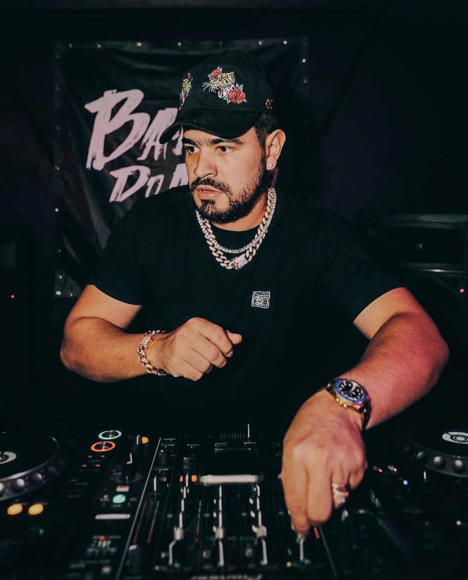 DJ operating turntables with a dark background and 'Bass' text.