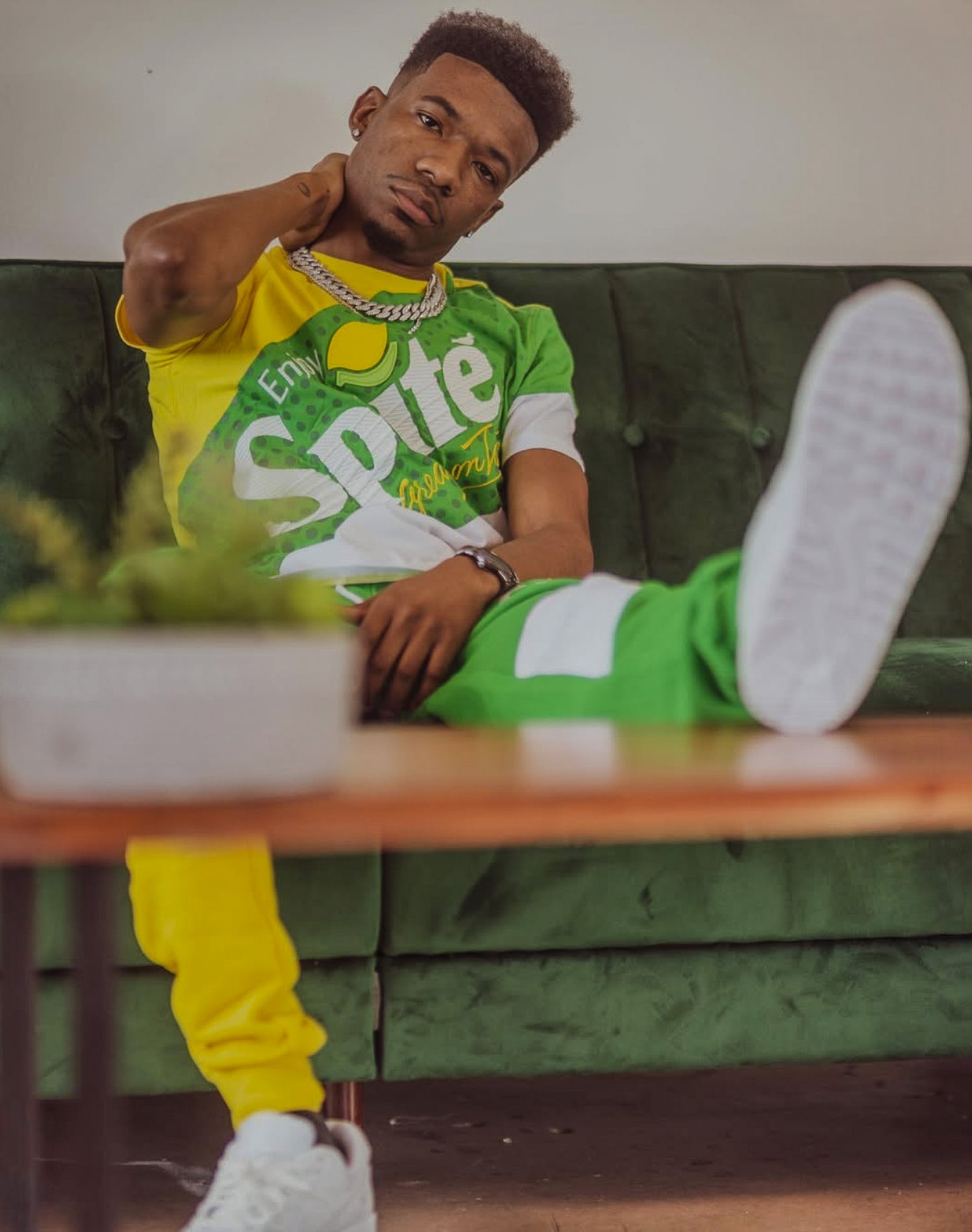 Person wearing a Sprite-themed outfit sitting on a green couch.
