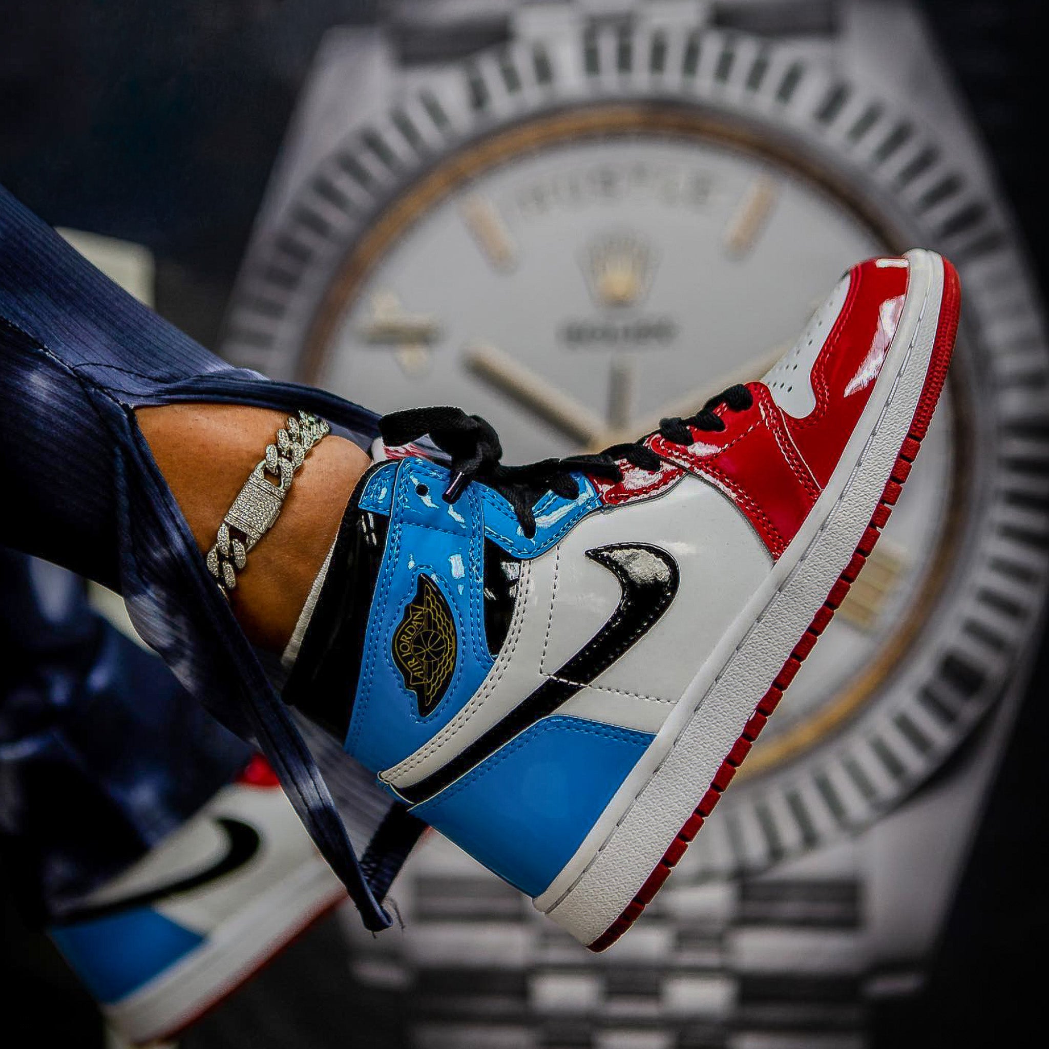 Blue and red sneakers with a blurred watch in the background