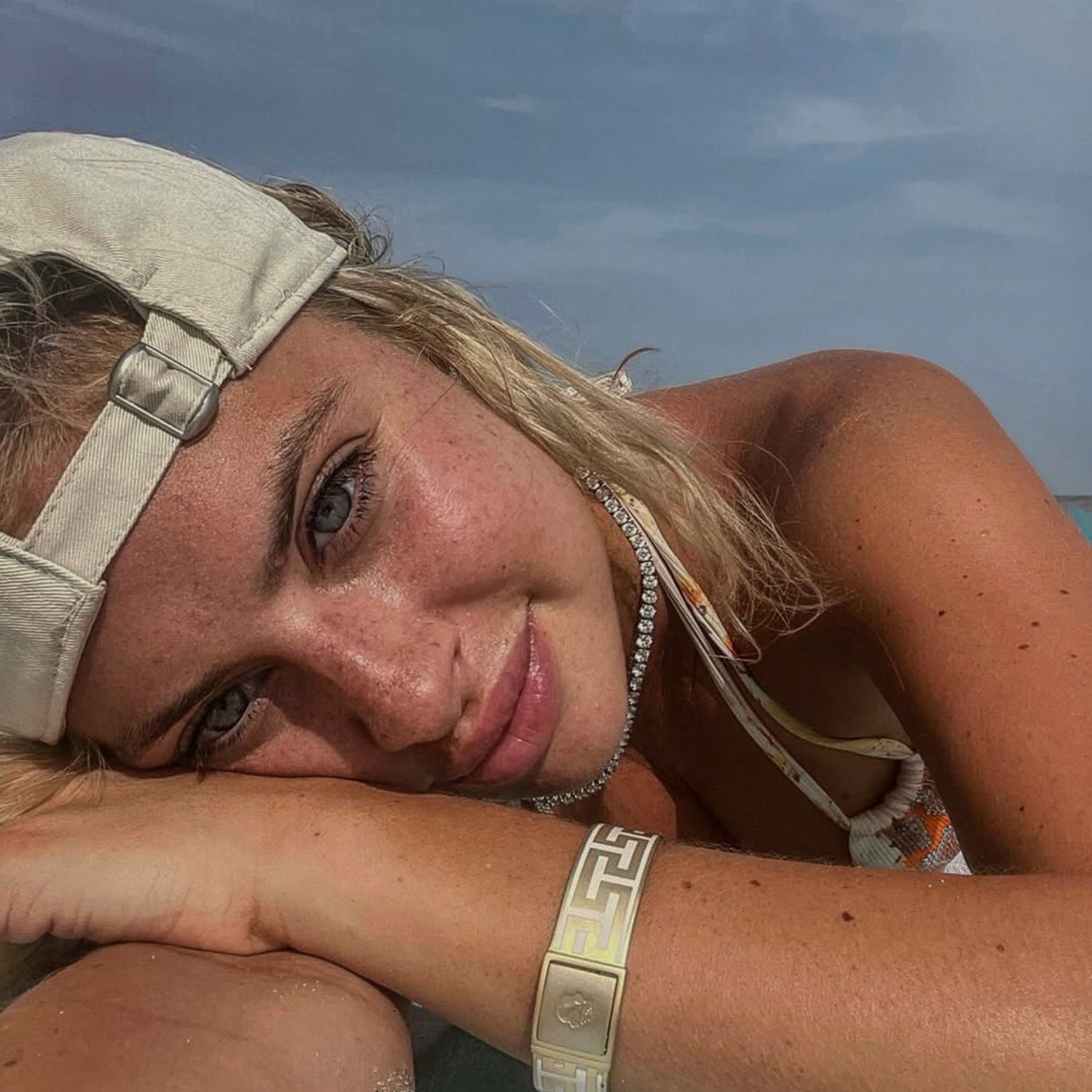 Woman wearing a cap and bracelet with a blurred background